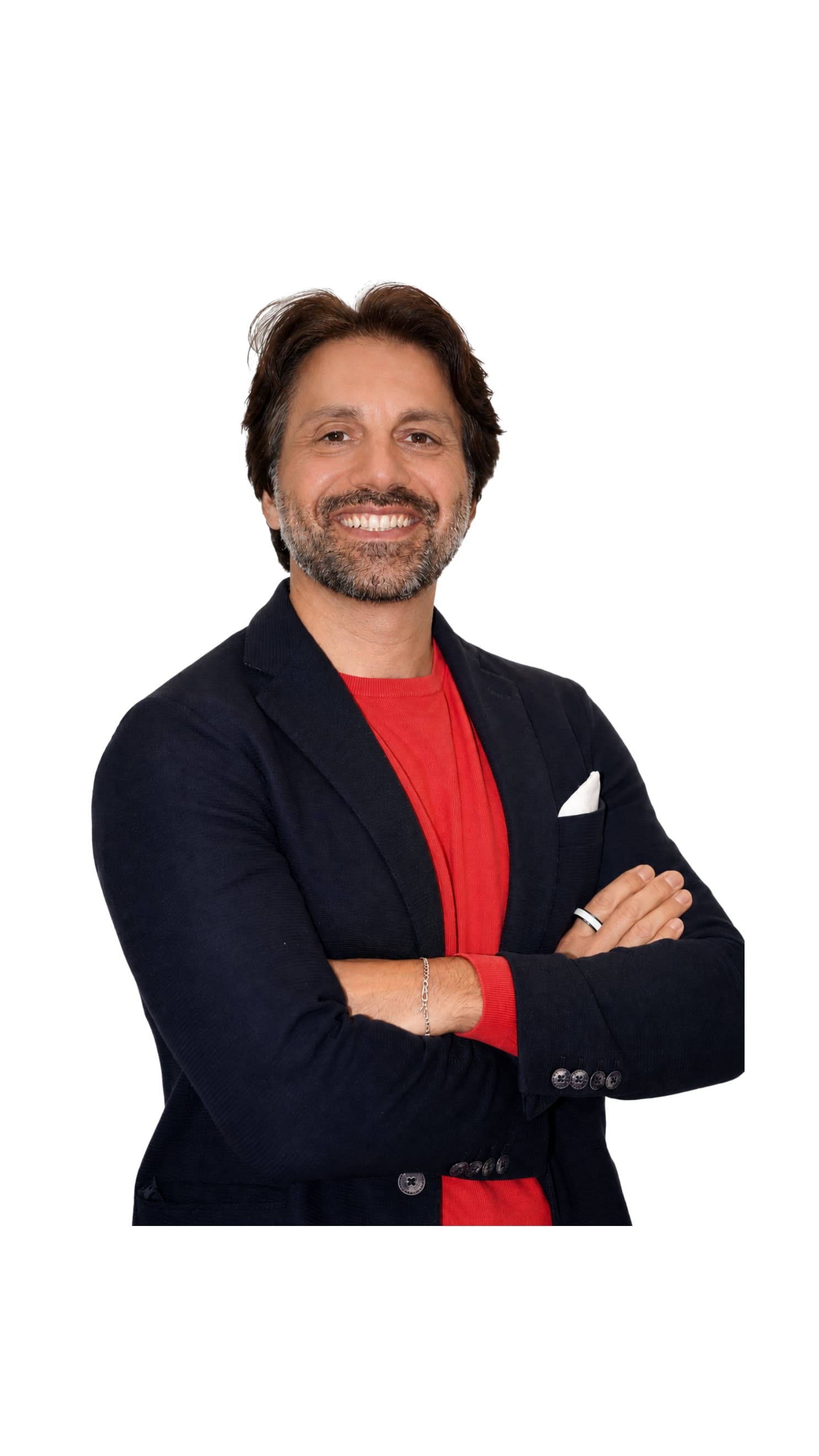 Uomo sorridente con barba brizzolata, indossa giacca blu e maglia rossa, braccia incrociate.